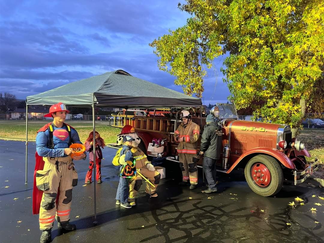 Eddie in firefighter gear with kids at a community event