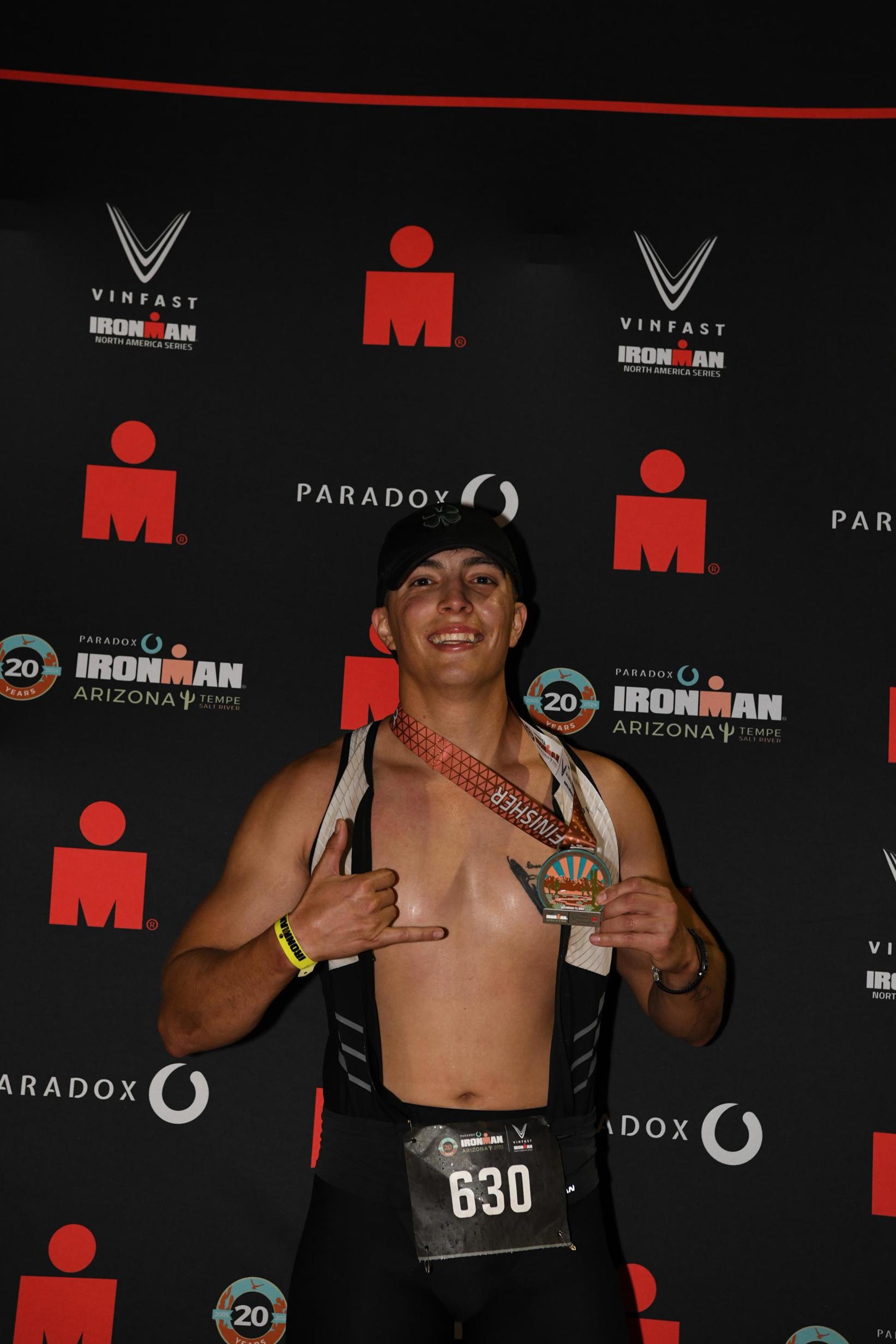 Eddie holding his Ironman Arizona finisher medal